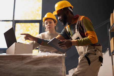 Diverse team managing in house operations in a small scale shipping facility, checking parcels and ensuring express delivery services. Supporting product retail e-commerce logistics.の写真素材