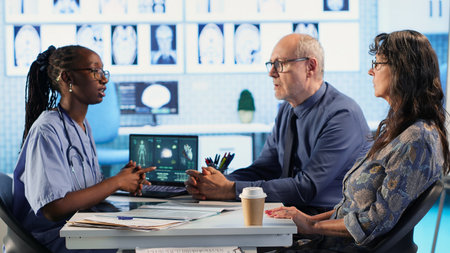 Medical assistant consulting senior patients about test results and MRI scans, reviewing hospital...