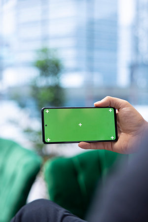 Goal oriented CEO reviews isolated mockup on phone focusing on investment planning, ensuring strong financial stability with corporate trends in a competitive marketplace. Close up.の写真素材