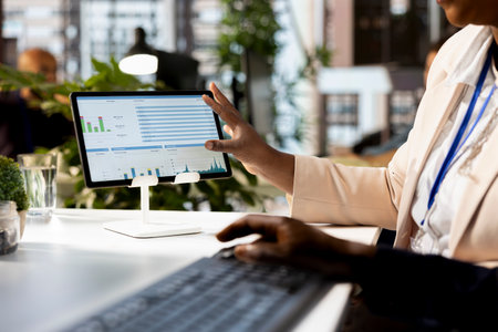 African american business associates reviewing data analytics and performance metrics in a modern...