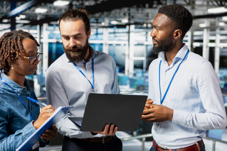 Team leader and workers reviewing performance dashboards of AI equipment. Engineers overseeing...