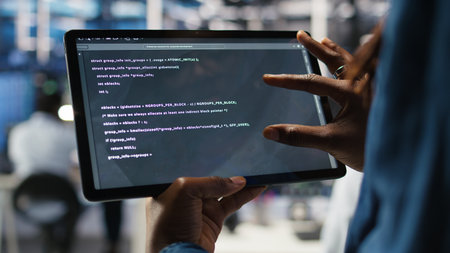 Close up of data center software developer checking code on tablet used to update equipment. Server...