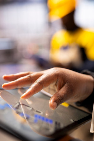 Closeup of technician leveraging a digital app to enhance solar energy output. Selective focus on...