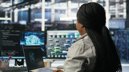 Data center admin uses AI technology on laptop for machine learning workloads. Server hub worker...