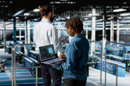 African american IT professional working on pc in high tech data center, handling maintenance tasks...