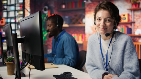 Portrait of smiling call center agent next to coworkers tracking shipments in office, solving tasks....