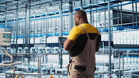 Industry 4.0 industrial plant expert designs new robotic machines using CAD program on tablet. Man...