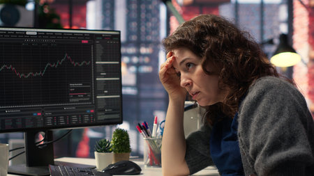 Day trader feeling worried and stressed looking at monetary losses, analyzing stock price trends on...