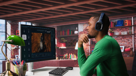 African American person uses AI chatbot to generate a video montage at home office, deep learning...