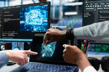 Close up of technicians coding in data center, updating AI driven automation scripts. IT specialists working in server hub, programming artificial intelligence algorithms, debugging equipmentの写真素材