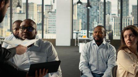 Colleagues sharing reports and visual data on computer in office. Work team performs risk assessment, strategy planning and data visualization to ensure strong performance and progress.の写真素材