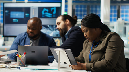 Photovoltaics plant researchers work on breakthroughs in durability and performance in office. Factory experts testing materials for next generation solar panels, doing research and developmentの写真素材