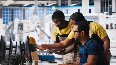 Colleagues troubleshooting solar equipment from computer station in a sustainable industrial...