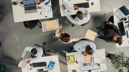 Top down view of colleagues checking archived files in workplace, reviewing charts and analytics....