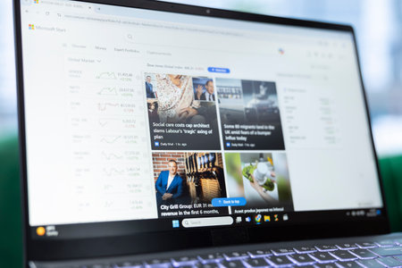 Bucharest, Romania - July 30th 2024 - Business director reading daily news online, using Microsoft Start web page to stay connected with the international events. Surfing the internet at the office.のeditorial素材