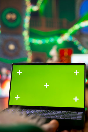 Close up of Santa using isolated screen laptop in workshop to check heartfelt messages from kids...