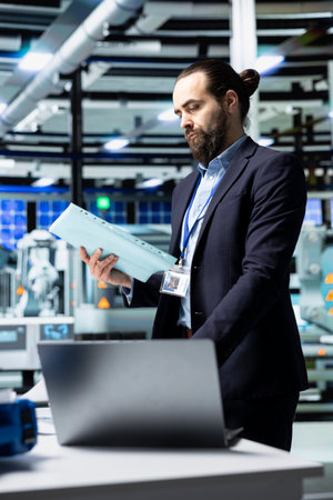 Business inspector oversees solar energy systems in industrial workplace, emphasizing strategic planning for sustainable energy development. Innovation in clean power production line.の写真素材