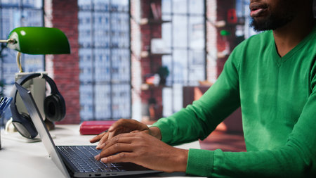 African american male freelancer at home focused on online research and surfing the internet,...