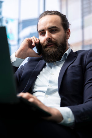 Corporate administrator in negotiation over the phone line, finalizing an agreement with partners after analyzing data and risks. Contacting people regarding international business.の写真素材