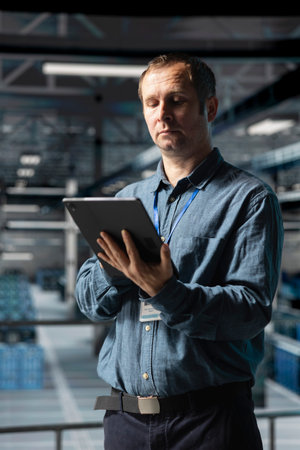 Admin on data center industrial platform analyzing infrastructure performance, ensuring error free operations. Server farm employee doing job tasks, upgrading components for increased storage capacityの写真素材