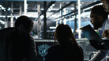 Server hub engineering team works together during a security incident. Data center colleagues collaborate to contain a virus and protect systems, camera Bの写真素材