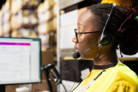 Close up of call center staff assisting clients in a distribution center, handling inventory and package tracking in warehouse. Woman resolving issues related to delivery delays or order mix up.の写真素材