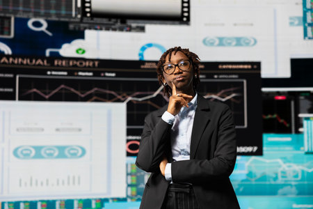 Business manager thinking of ideas to increase company profits while looking at charts on screens. Businesswoman using insights and KPI projections for strategic decision makingの写真素材