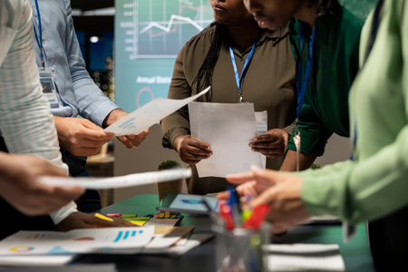 Diverse project team meeting after hours to share data visualization reports, discuss business intel and prepare forecasts for upcoming presentations to enterprise shareholders after hours.の写真素材