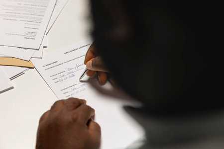 Close up of candidate signing a job contract after successful interview and HR approval, recruiter and applicant sit together to review the legal terms of employment. New professional beginning.の写真素材