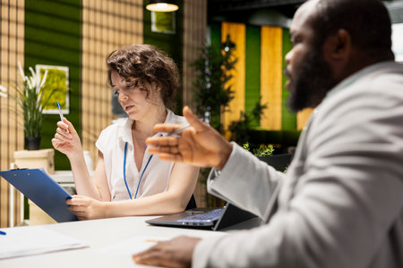 HR admin conducting a job interview with a black hopeful candidate with amazing experience and recommendations. Doing a professional evaluation for alignment with corporate hiring standards.の写真素材