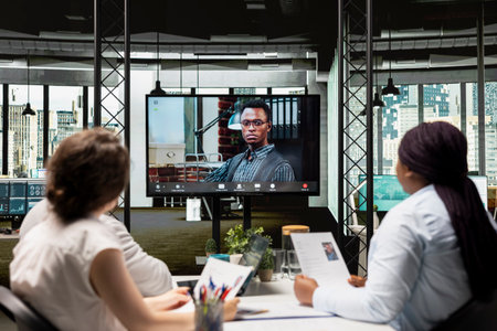 Recruiters conducting an online video interview with a candidate to evaluate employment history,...