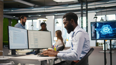System administrator in tech startup office using PC, troubleshooting hardware and software issues....