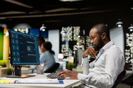 Smart AI assistant displayed on a computer monitor helping black man complete tasks at night, power...