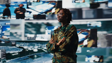 Intelligence agency specialist scanning enemy rockets using digital videowall. African american woman using radar systems on laptop program to detect incoming ballistic missiles, camera Aの写真素材