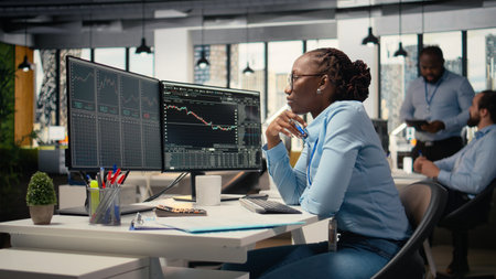 Forex expert in office looking over candlestick charts on screen to assess stock market volatility....