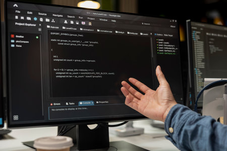 Close up of software developer coding on PC in startup office, refining machine learning models to...