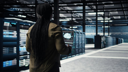 Data center engineer using deep learning on laptop to optimize operations efficiency. IT expert...