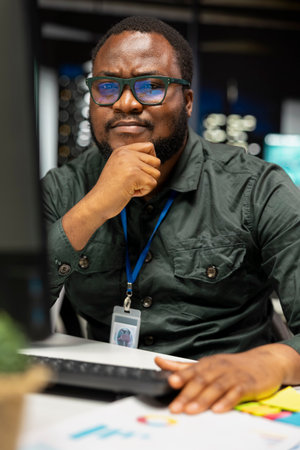 African american businessman strategizing late at night in the office, thinking about ways to achieve a successful career. Intuitive and methodical thinking for multiple solutions.の写真素材