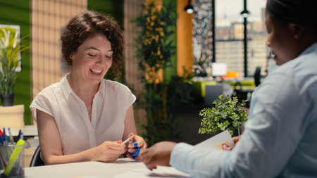 Applicant receives a photo ID card security pass from human resources in onboarding meeting, confirming the approved employment process. Exciting new beginning for business job.の写真素材