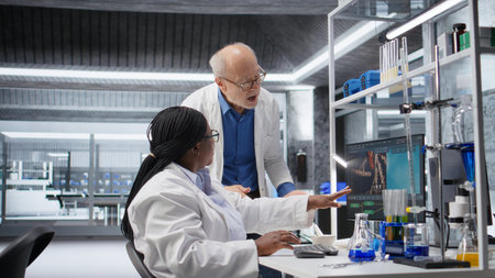 Woman scientist examines experiment data with coworker in a laboratory, driving progress in...