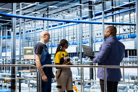 Supervisor overseeing solar panel factory floor operations and work done by engineers. African...
