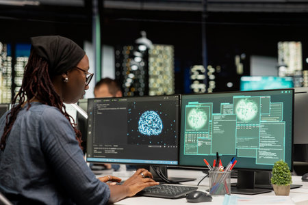 Software developer at office desk doing maintenance on computer systems using AI. African american...