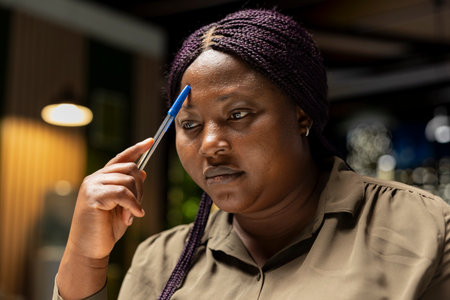 General manager engages in methodical planning after hours at the corporate office, envisioning ideas and reflecting on business outlooks to turn a challenging problem into a tactical solution.の写真素材