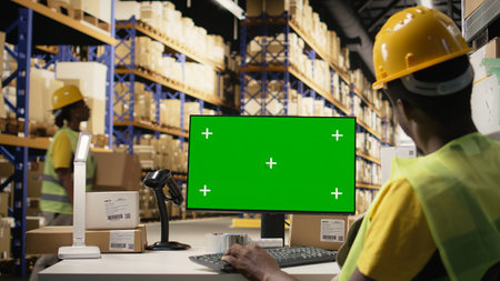 Man overseeing distribution activity and protocols with mockup on pc, working on large scale industrial operations for retail e-commerce industry. Storehouse with boxes on racks. Camera A.の写真素材