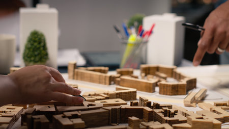 Close up of urban developers showing master plan for residential layout project, using 3D models on table to present idea of a smart city. Site preparation for infrastructure growth.の写真素材