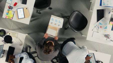 Top down view of coworkers collaborate on report writing and data visualization. The team focuses on performance objectives, management strategy and efficient report sharing.の写真素材