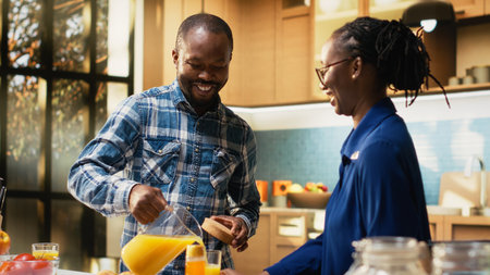 Smiling couple enjoying morning coffee while preparing croissants for breakfast. Cheerful boyfriend...