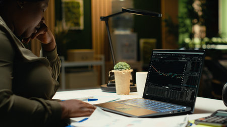 Black woman distressed about stock market trends going down and losing money, feeling scared and...