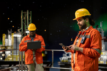 Drilling ship technician managing operational workflows using tablet app during night shift....