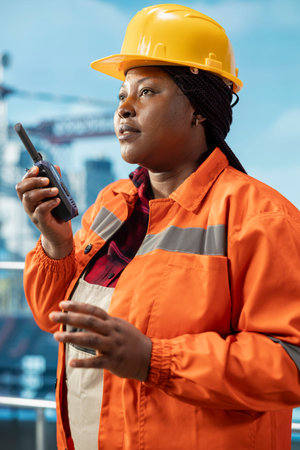 Closeup of oil company manager on drilling barge using walkie talkie to ensure uninterrupted...